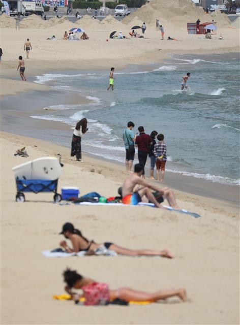 해수욕장 부분 개장을 하루 앞둔 31일 오후 부산 해운대 해수욕장을 찾은 관광객들이 바다를 즐기고 있다. 부산 해운대, 송정 해수욕장은 6월 1일부터 8월 31일까지 운영할 계획이며, 6월 한 달은 파라솔,샤워,탈의장 등 시설물은 운영하지 않는다. 2021.5.31 뉴스1