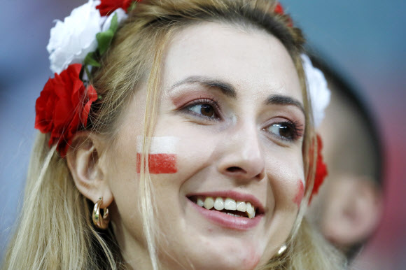 1일(현지시간) 폴란드 보로츠와프의 미에이스키 스타디움에서 열린 폴란드와 러시아의 친선경기에서 폴란드 축구팬이 꽃화관을 쓰고 환하게 미소짓고 있다. 로이터 연합뉴스