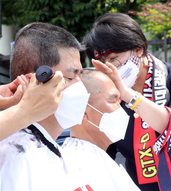 더불어민주당 박상혁(김포 을) 의원과 김주영 의원(김포 갑)이 2일 정부세종청사 국토교통부 앞에서 삭발 결의를 하며 ‘GTX-D노선 원안사수 및 서울 5호선 김포 연장’을 촉구하고 있다. 2021.6.2 뉴스1