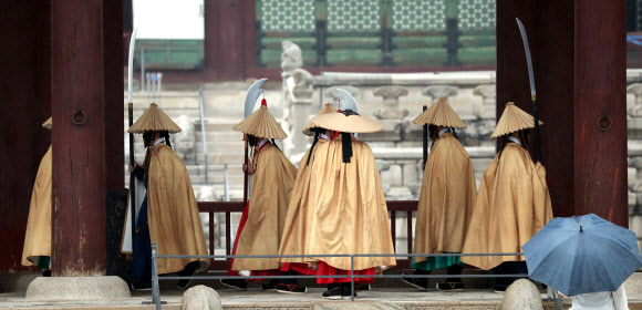 전통 비옷인 도롱이를 입은 궁궐 수문장이 비가 내린 3일 오후 경복궁 근정문에서 근무를 교대하고 있다. 2021.6.3  연합뉴스