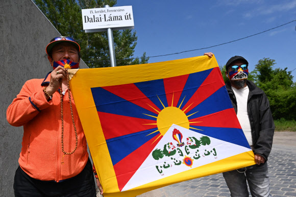 지난 2일 헝가리 수도 부다페스트 페렌츠바로시 지역에 새로 명명된 ‘달라이 라마’길에서 활동가들이 티베트 깃발을 들고 정부에 항의 시위를 하고 있다. 부다페스트시는 빅토르 오르반 총리가 중국 푸단대 분교를 세우려고 하자 이에 항의해 대학 예정부지 인근 거리를 반중 관련 명칭으로 바꿨다. 부다페스트 AFP 연합뉴스