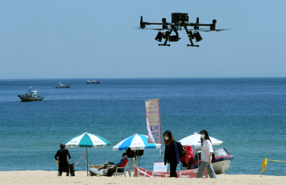 4일 강원 강릉시가 해수욕장에서 코로나19가 확산하는 것을 막기 위해 열화상 카메라를 부착해 체온이 높은 발열 환자를 확인하는 드론을 경포해변에서 선보이고 있다. 2021.6.4  연합뉴스
