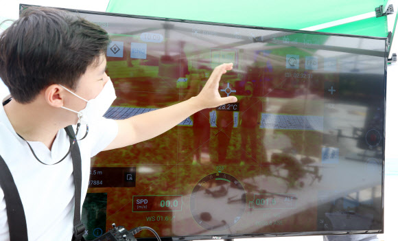 4일 강원 강릉시 경포해변에서 드론업체 관계자가 열화상 카메라를 부착한 드론이 보내온 영상을 설명하고 있다. 강릉시는 코로나19 확산을 막기 위해 올여름 발열 환자를 확인하는 드론을 주요 해변에 투입할 예정이다. 2021.6.4  연합뉴스