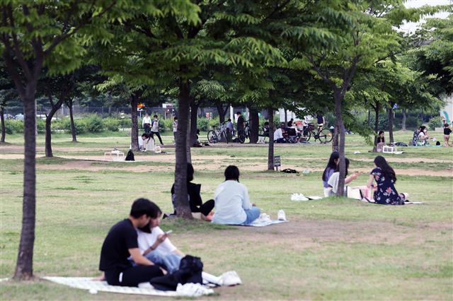 낮 기온이 30도 안팎으로 높아진 6일 오전 서울 영등포구 여의도 한강공원에서 나들이를 나온 시민들이 그늘에 돗자리를 펴놓고 휴일을 보내고 있다. 2021.6.6 뉴스1