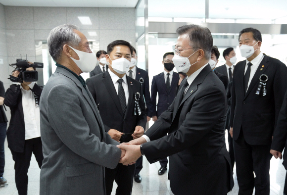 문재인 대통령이 6일 서울 동작구 국방부 유해발굴감식단 신원확인센터를 방문, 최근에 신원이 확인된 고 일병 강성기의 남동생 강성남씨와 인사를 하고 있다. 2021. 6. 6  도준석 기자 pado@seoul.co.kr