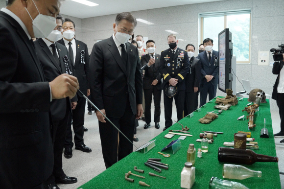 문재인 대통령과 부인 김정숙 여사가 6일 서울 동작구 국방부 유해발굴감식단 신원확인센터를 방문, 유해감식실에서 허욱구 유해발굴단장으로부터 설명을 듣고 있다. 2021. 6. 6  도준석 기자 pado@seoul.co.kr