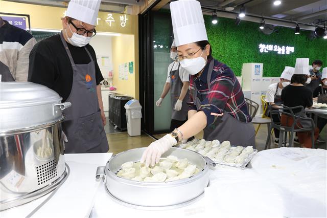 김미명(오른쪽) 서울 은평구청장이 지난달 29일 대조동 은평오랑에서 ‘놀면 뭐하니? 만두 가지러 오랑!’ 행사에 참석해 1인가구 청년에게 전달할 만두를 빚고 있다.<br>은평구 제공