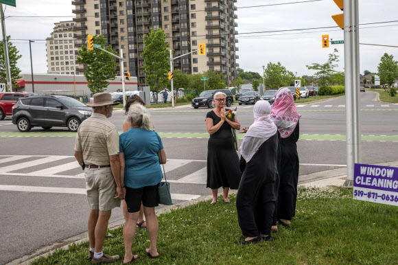 캐나다 온타리오주 런던 주민들이 지난 6일(이하 현지시간) 밤 트럭에 치여 무슬림 일가족 넷이 목숨을 잃고 아홉 살 소년만 살아남은 현장을 다음날 찾아 애꿎게 희생된 이들을 위해 기도를 올리며 무슬림 주민들을 위무하고 있다. 런던 캐너디언 프레스 AP 연합뉴스