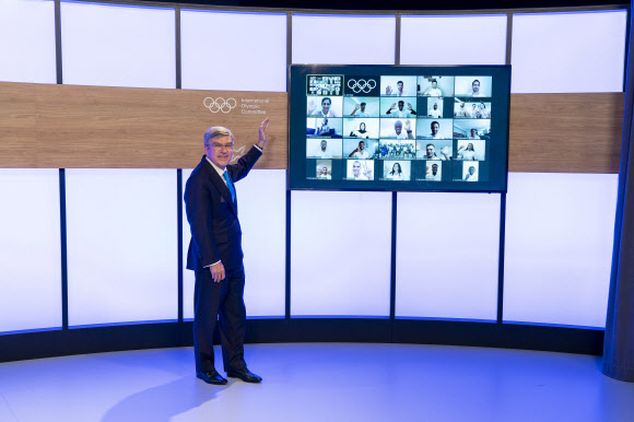 토마스 바흐 국제올림픽위원회(IOC) 위원장이 8일(현지시간) 스위스 로잔 본부에서 2020 도쿄올림픽에 출전할 난민 팀 11개국 출신 29명의 사진들을 소개하고 있다. IOC 제공 로이터 연합뉴스 