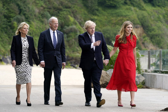 10일(현지시간) 영국 콘월에서 손을 잡고 걷는 조 바이든 미 대통령 부부(왼쪽)와 보리스 존슨 영국 총리 내외. AP