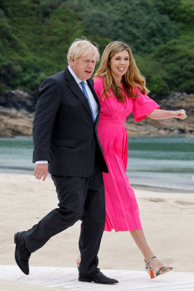 영국 콘월에서 G7 정상회의가 열리는 가운데 11일(현지시간) 보리스 존슨 영국 총리와 캐리 존슨 영부인이 각국의 지도자들을 맞이하기에 앞서 해변을 산책하고 있다. AFP 연합뉴스