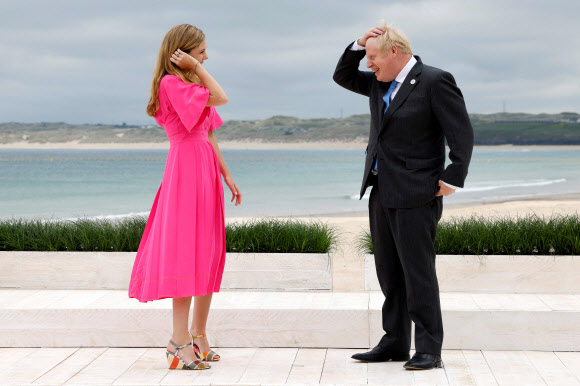 영국 콘월에서 G7 정상회의가 열리는 가운데 11일(현지시간) 보리스 존슨 영국 총리와 캐리 존슨 영부인이 각국의 지도자들을 맞이하기에 앞서 해변을 산책하고 있다. AFP 연합뉴스