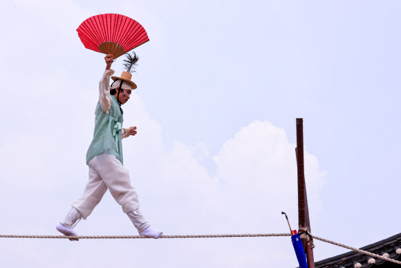 남산국악당 주최로 14일 오후 서울 중구 남산골한옥마을에서 열린 ‘라이브(LIVE) 남산’ 행사에서 줄타기 명인 남창동 씨가 공연을 펼치고 있다.  라이브 남산은 포스트 코로나 시대의 다양한 관객 경험을 수용하기 위해 온오프라인 통합 콘텐츠 공연으로 기획됐다. 한옥마을 야외 공간에 30명 이내의 예약 관객을 받고 온라인 플랫폼을 통해서도 공연을 생중계한다. 2021.6.14  연합뉴스