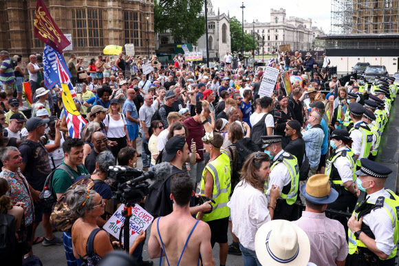14일(현지시간) 영국 런던 국회의사당 광장에서 코로나19 봉쇄 해제 연기와 백신 접종에 항의하는 시위대가 집회를 벌이고 있다. 로이터 연합뉴스