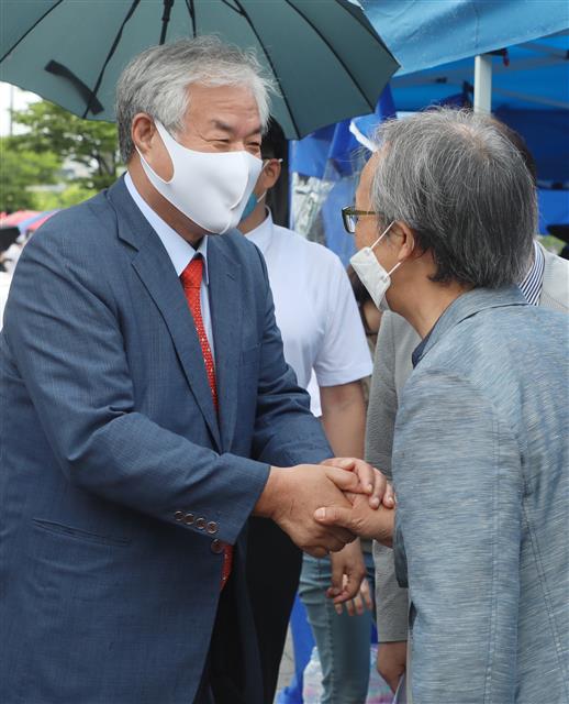 전광훈 목사가 15일 전북 전주시 전북도청 앞에서 열린 ‘헌법·보안법 폐기 결사반대 국민혁명당 기자회견’에서 지지자와 악수를 하고 있다. 2021.6.15 뉴스1