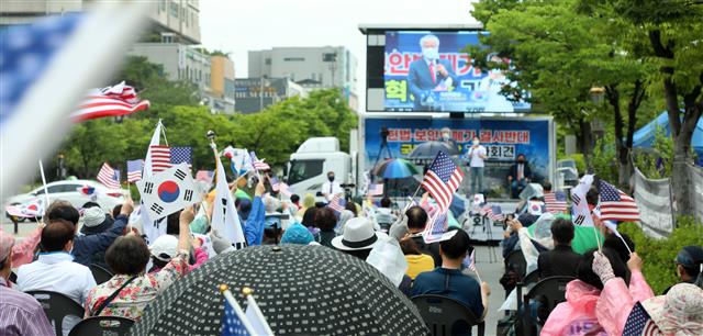 15일 전북 전주시 전북도청 앞에서 열린 ‘헌법·보안법 폐기 결사반대 국민혁명당 기자회견’에서 전광훈 목사의 지지자들이 연신 태극기와 성조기를 흔들며 환호하고 있다. 2021.6.15 뉴스1