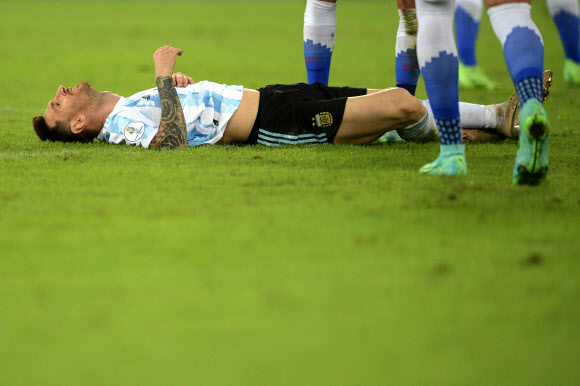 아르헨티나의 리오넬 메시가 15일(한국시간) 브라질 리우데자네이루 주앙 아벨란제 올림픽 경기장에서 열린 칠레와의 2021 코파 아메리카 A조 1차전 도중 상대 선수와 부딪힌 뒤 그라운드에 쓰러져 있다. 리우데자네이루 AFP 연합뉴스