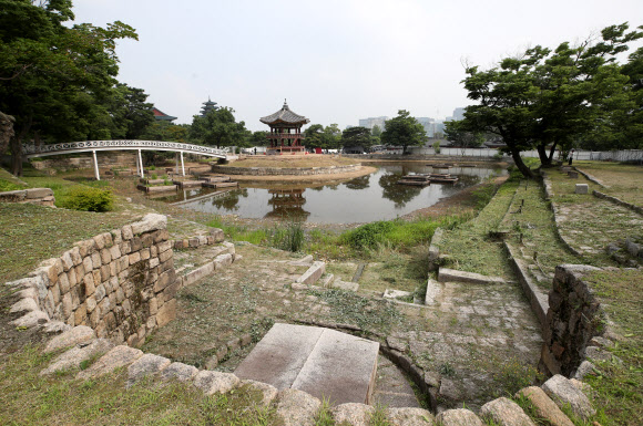 지난 2017년 5월 해체·보수 공사를 시작한 경복궁 북쪽의 아름다운 육각 정자 ‘향원정’(香遠亭)이 올가을 정비를 마치고 공개된다. 지금도 향원정을 둘러싼 연못인 향원지(香遠池) 주변 가림막 사이로 정자와 물 빠진 연못을 볼 수 있지만, 10월이면 공식적으로 공사를 마무리한다. 연못 조경 작업까지 마무리되는 시점은 내년 봄이다. 사진은 지난 14일 막바지 보수 작업이 한창인 향원정 연못의 열상진원 샘. 경복궁 창건(1395년) 당시부터 있던 왕궁의 샘으로, 글을 새긴 우물 뚜껑은 경복궁 중건(1868년)때 만든 것이다. 2021.6.16  연합뉴스