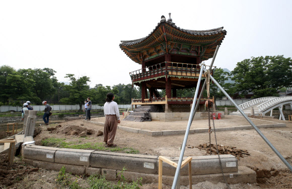 지난 2017년 5월 해체·보수 공사를 시작한 경복궁 북쪽의 아름다운 육각 정자 ‘향원정’(香遠亭)이 올가을 정비를 마치고 공개된다. 지금도 향원정을 둘러싼 연못인 향원지(香遠池) 주변 가림막 사이로 정자와 물 빠진 연못을 볼 수 있지만, 10월이면 공식적으로 공사를 마무리한다. 연못 조경 작업까지 마무리되는 시점은 내년 봄이다. 사진은 지난 14일 막바지 보수 작업이 한창인 향원정. 2021.6.16  연합뉴스