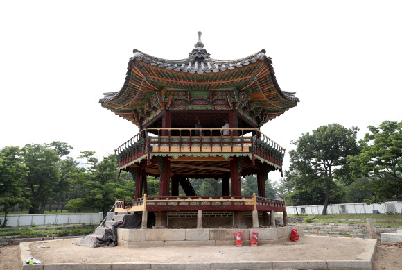 지난 2017년 5월 해체·보수 공사를 시작한 경복궁 북쪽의 아름다운 육각 정자 ‘향원정’(香遠亭)이 올가을 정비를 마치고 공개된다. 지금도 향원정을 둘러싼 연못인 향원지(香遠池) 주변 가림막 사이로 정자와 물 빠진 연못을 볼 수 있지만, 10월이면 공식적으로 공사를 마무리한다. 연못 조경 작업까지 마무리되는 시점은 내년 봄이다. 사진은 지난 14일 막바지 보수 공사가 한창인 향원정. 2021.6.16  연합뉴스