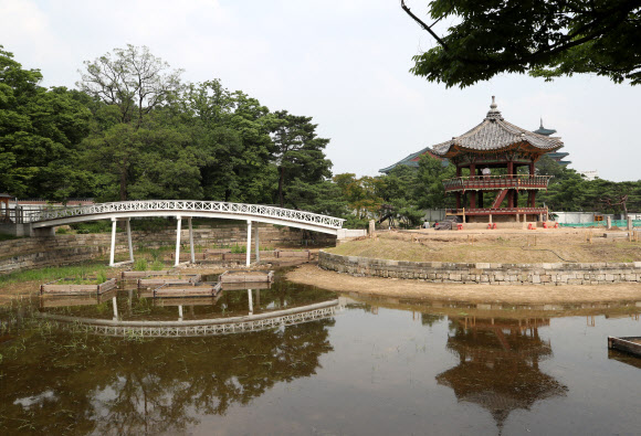 지난 2017년 5월 해체·보수 공사를 시작한 경복궁 북쪽의 아름다운 육각 정자 ‘향원정’(香遠亭)이 올가을 정비를 마치고 공개된다. 지금도 향원정을 둘러싼 연못인 향원지(香遠池) 주변 가림막 사이로 정자와 물 빠진 연못을 볼 수 있지만, 10월이면 공식적으로 공사를 마무리한다. 연못 조경 작업까지 마무리되는 시점은 내년 봄이다. 사진은 지난 14일 막바지 보수 작업이 한창인 향원정. 2021.6.16  연합뉴스