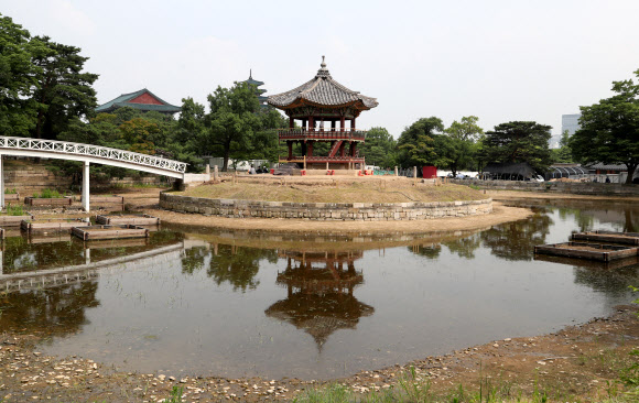 지난 2017년 5월 해체·보수 공사를 시작한 경복궁 북쪽의 아름다운 육각 정자 ‘향원정’(香遠亭)이 올가을 정비를 마치고 공개된다. 지금도 향원정을 둘러싼 연못인 향원지(香遠池) 주변 가림막 사이로 정자와 물 빠진 연못을 볼 수 있지만, 10월이면 공식적으로 공사를 마무리한다. 연못 조경 작업까지 마무리되는 시점은 내년 봄이다. 사진은 지난 14일 막바지 보수 작업이 한창인 향원정. 2021.6.16  연합뉴스
