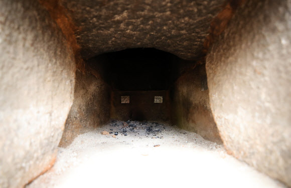 지난 2017년 5월 해체·보수 공사를 시작한 경복궁 북쪽의 아름다운 육각 정자 ‘향원정’(香遠亭)이 올가을 정비를 마치고 공개된다. 지금도 향원정을 둘러싼 연못인 향원지(香遠池) 주변 가림막 사이로 정자와 물 빠진 연못을 볼 수 있지만, 10월이면 공식적으로 공사를 마무리한다. 연못 조경 작업까지 마무리되는 시점은 내년 봄이다. 사진은 지난 14일 막바지 보수 작업이 한창인 향원정의 아궁이. 온돌시설이 설치된 정자는 드물다. 2021.6.16  연합뉴스