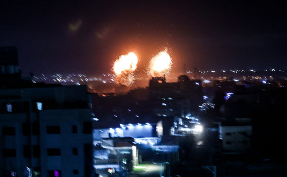 이스라엘이 팔레스타인의 자치를 허용한 가자지구의 건물들에서 16일 이스라엘 군의 공습으로 인한 화염이 치솟아 밤하늘을 밝히고 있다. 가자 시티 AFP 연합뉴스 