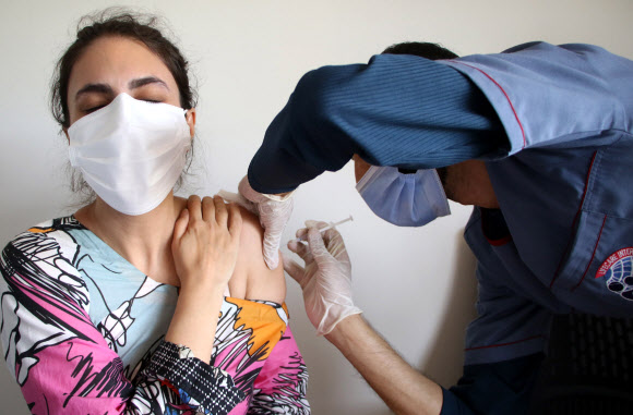 백신을 접종받고 있는 파키스탄 이슬라마바드의 건강 관련업 종사자. 파키스탄 출신 이주노동자가 많은 사우디아라비아가 중국산 백신을 승인하지 않으면서 파키스탄 내에서는 최근 화이자 백신 도입을 촉구하는 목소리가 커지고 있다. 2021.6.15  EPA 연합뉴스
