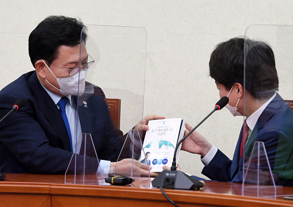 이준석 국민의힘 대표가 17일 오후 서울 여의도 국회에서 송영길 더불어민주당 대표와 예방 인사 후 송대표로 부터 저서를 선물 받고 있다.2021. 6. 17  김명국 선임기자 daunso@seoul.co.kr