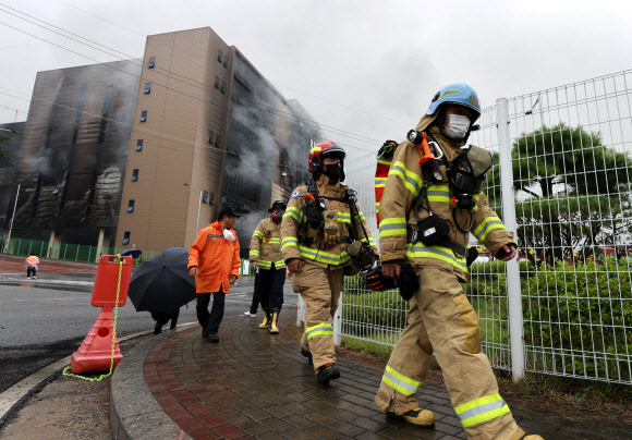 18일 오전 경기도 이천시 마장면 쿠팡 덕평물류센터 화재 현장에서 소방관들이 이동하고 있다.이 화재로 소방관 1명이 불이 난 건물에 고립됐지만 불길이 잡히지 않아 내부 수색이 불가능한 상황이어서 소방당국은 수색작업을 일시 중단한 상태다. 연합뉴스