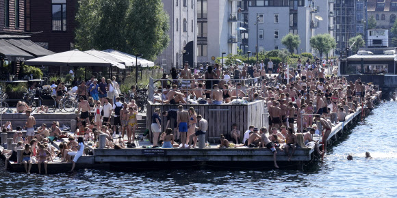 30도가 넘는 더운 여름날, 사람들이 18일(현지시간) 덴마크 코펜하겐의 항구에서 일광욕과 다과를 즐기고 있다. 2021-06-19 AP 연합뉴스