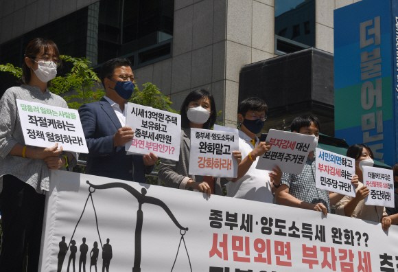 21일 서울 영등포구 더불어 민주당 당사 앞에서 열린 ‘부자감세 추진하는 더불어 민주당 규탄’ 기자회견에 참석한 참여연대 소속 회원들이 피켓을 들고 있다. 2021.6.21 박지환기자 popocar@seoul.co.kr