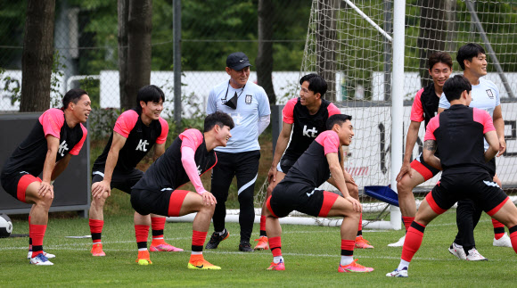 한국 올림픽 축구 대표팀 김학범(가운데) 감독이 22일 경기도 파주 국가대표팀트레이닝센터로 소집된 선수들과 몸을 풀며 이야기를 나누고 있다. 연합뉴스