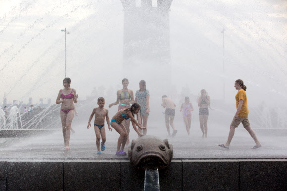 사람들이 22일(현지시간) 러시아 상트 페테르부르크의 한 공원에서 물놀이를 하며 즐거운 시간을 보내고 있다. 최근 며칠 동안 상트 페테르부르크에 최고 기온이 섭씨 30도를 넘는 폭염이 이어지고 있다. 신화 연합뉴스
