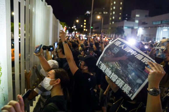 지난 26년 동안 홍콩의 민주화를 앞장서 부르짖은 빈과일보를 아끼는 시민들이 24일 새벽 사옥 앞에 몰려와 마지막으로 발간된 신문 1면을 펼쳐 보이며 그동안의 노고를 치하하고 있다. 홍콩 로이터 연합뉴스 