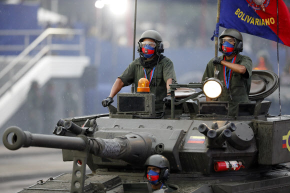 Soldiers drive their armored vehicle during the military parade marking the 200th anniversary of the battle of Carabobo in Carabobo, Valencia state, Venezuela, Thursday, June 24, 2021. The battle of Carabobo, on June 24, 1821, led by independence hero Simon Bolivar, was decisive in gaining Venezuela‘s independence from Spain. (AP Photo/Ariana Cubillos)