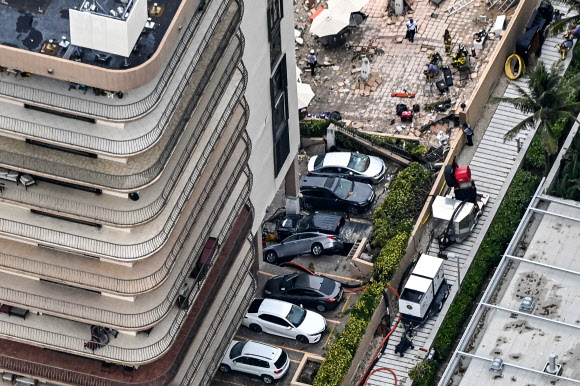 This aerial view, shows search and rescue personnel working on site after the partial collapse of the Champlain Towers South in Surfside, north of Miami Beach, on June 24, 2021. - The multi-story apartment block in Florida partially collapsed early June 24, sparking a major emergency response. Surfside Mayor Charles Burkett told NBC?s Today show: ?My police chief has told me that we transported two people to the hospital this morning at least and one has died. We treated ten people on the site.? (Photo by CHANDAN KHANNA / AFP)/2021-06-25 06:08:52/ <연합뉴스