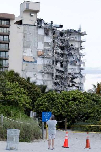 24일(현지시간) 미국 플로리다주 마이애미데이드카운티 서프사이드에서 오전 1시30분께 12층짜리 챔플레인 타워 사우스 아파트 일부가 붕괴한 현장 모습. 로이터 연합뉴스