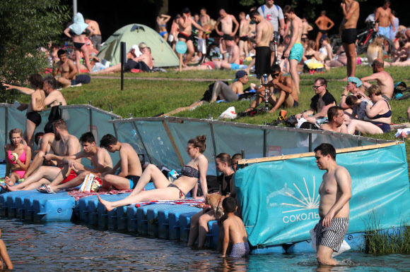 사람들은 26일(현지시간) 러시아 모스크바의 소콜니키 공원 연못에서 더위를 식히고 있다. 러시아 수도와 주변 지역은 낮 기온이 섭씨 30도를 넘으면서 덥고 맑은 날씨를 보이고 있다., 26일 모스크바의 낮 기온은 32도에 달했다. 타스 연합뉴스