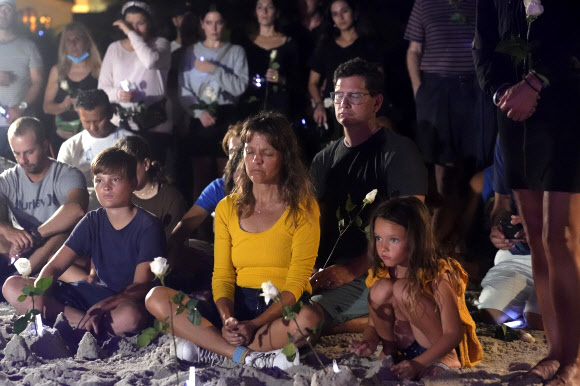 28일(현지시간) 사람들이 미국 플로리다주 서프사이드의 아파트 붕괴 현장에 모여 희생자들을 추모하고 있다. AP