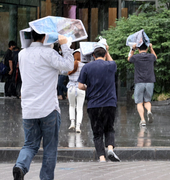 30일 오후 서울 중구 을지로 한 거리에서 시민들이 소나기를 피해 발걸음을 재촉하고 있다. 2021.6.30  연합뉴스