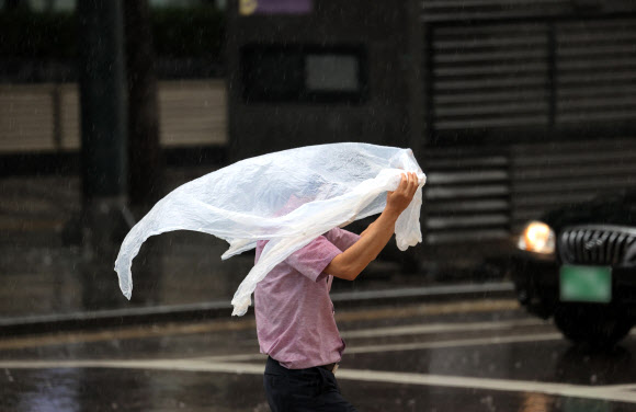 30일 오후 서울 중구 무교동의 한 거리에서 시민들이 소나기를 피해 발걸음을 재촉하고 있다. 2021.6.30  연합뉴스