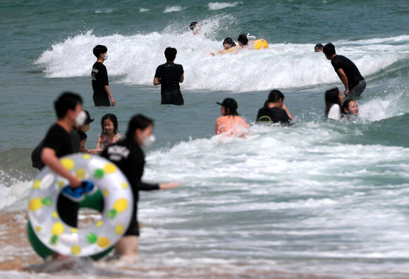 부산지역 7개 공설해수욕장 개장을 하루 앞둔 30일 오후 부산 해운대해수욕장에서 피서객들이 물놀이를 하고 있다. 2021.6.30  연합뉴스