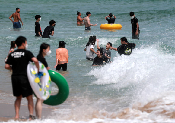 부산지역 7개 공설해수욕장 개장을 하루 앞둔 30일 오후 부산 해운대해수욕장에서 피서객들이 물놀이를 하고 있다. 2021.6.30  연합뉴스