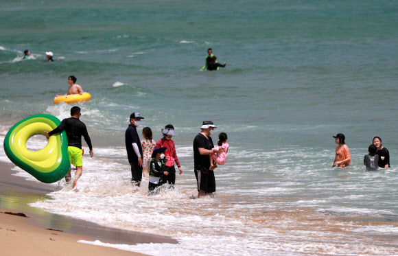 부산지역 7개 공설해수욕장 개장을 하루 앞둔 30일 오후 부산 해운대해수욕장에서 피서객들이 물놀이를 하고 있다. 2021.6.30  연합뉴스