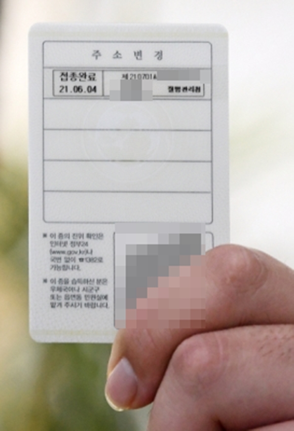 한 시민이 1일 서울 시내 한 주민센터에서 발급한 ‘백신 접종자 스티커’가 부착된 신분증을 들고 있다. 오장환 기자 5zzang@seoul.co.kr 　 