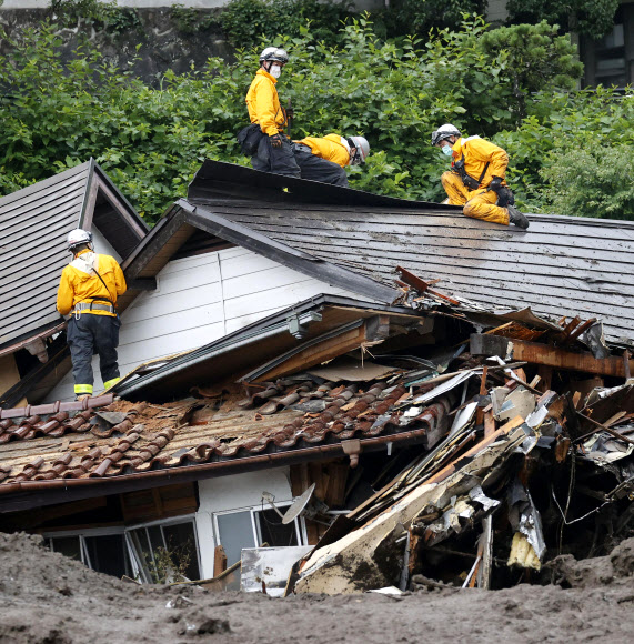 4일(현지시간) 일본 시즈오카현 아타미시 아즈산에서 기록적인 폭우로 산사태가 발생해 여러 채의 주택을 덮친 가운데 구조대원들이 수색작업을 벌이고 있다. AP 연합뉴스