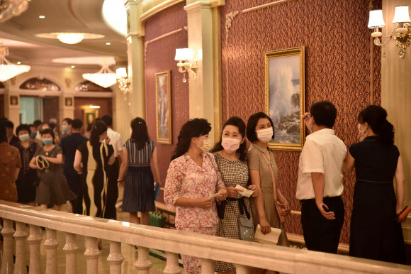 마스크를 쓴 북한 주민들이 3일 평양에서 열린 국무위원회 연주단의 공연을 관람하기 위해 삼지연극장에 도착하고 있다. AFP 연합뉴스