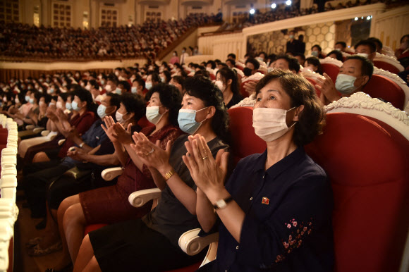 3일 북한 평양의 삼지연극장에서 마스크를 쓴 주민들이 국무위원회 연주단의 공연을 관람하면서 박수를 치고 있다. AFP 연합뉴스